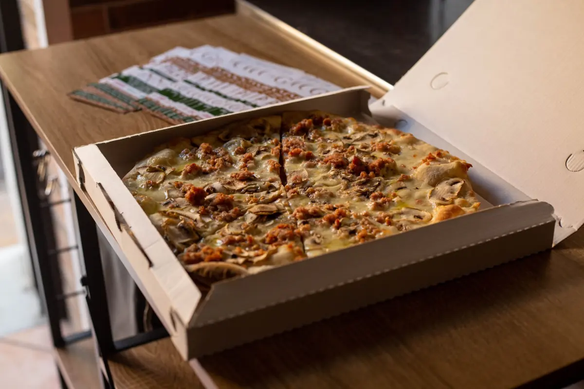 Una pizza tagliata nella scatola di Grano, pronta da ritirare al banco
